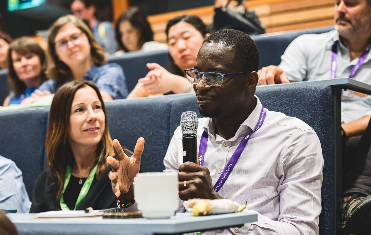 A seated person on a mictophone at a conference