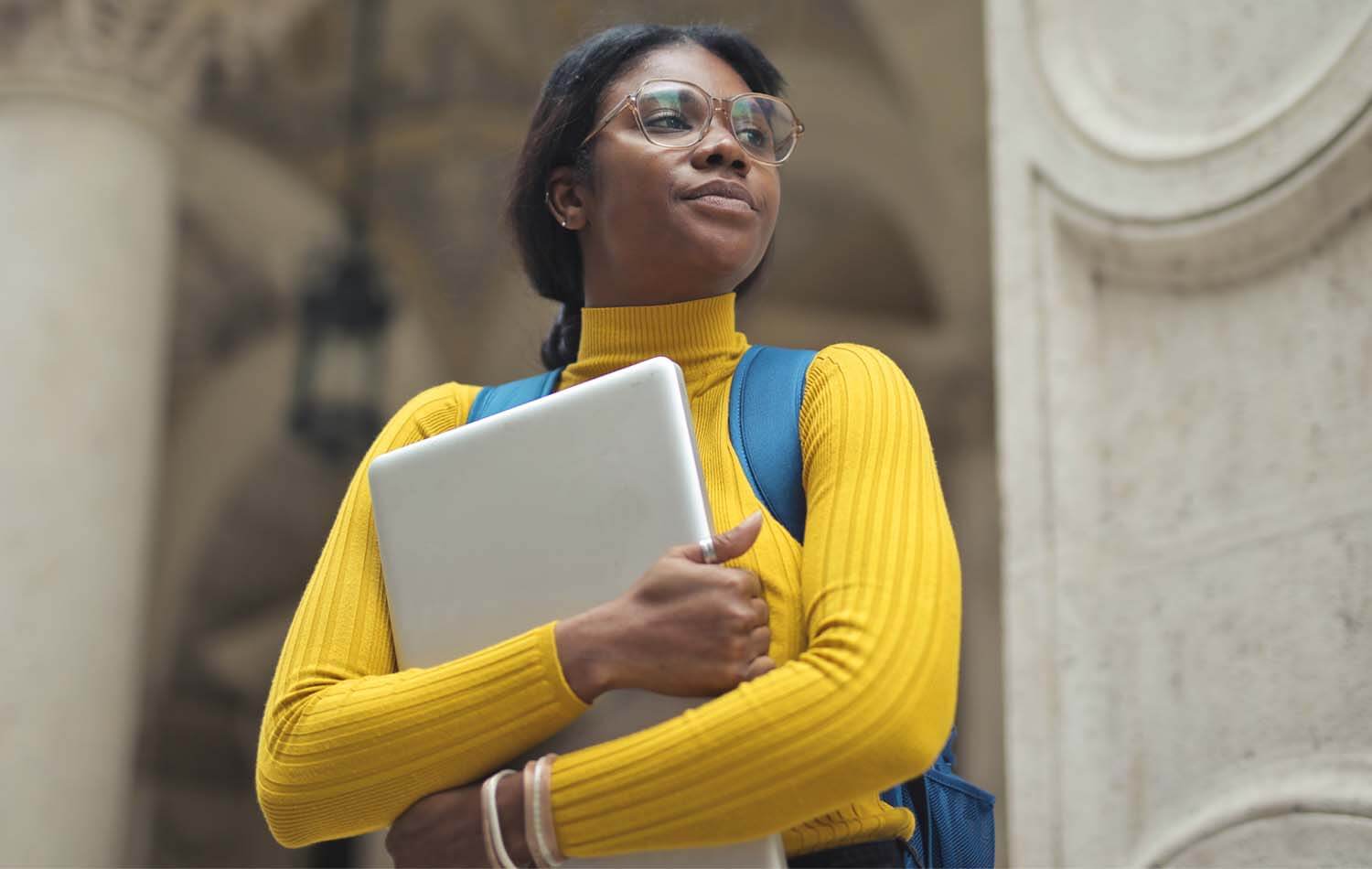 portrait-young-Nigerian-woman-with-laptop-hands-outside-school